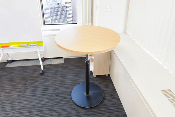 執務エリアの近くに小テーブルを用意しておいて、すぐに集まってスタンディングミーティングができる。もちろん近くにはホワイトボードもある。この小テーブルは上下昇降できるので、座ってのミーティングにも使える。
