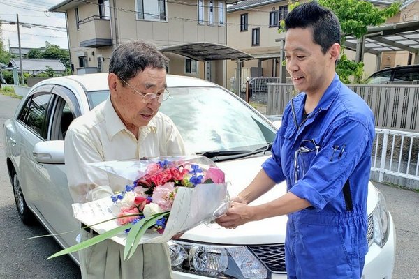 免許を返納する顧客に花束を贈呈する瀬川オート商会の瀬川社長（※）