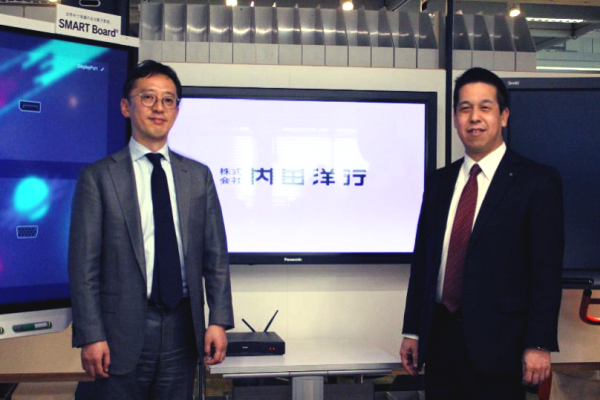 矢野直哉さん（右）と橋本雅司さん（左）。左に見える大型電子ボード「SMART Board」は、書き込みができ、ワイヤレスで画面共有もできる未来型ホワイトボード。
